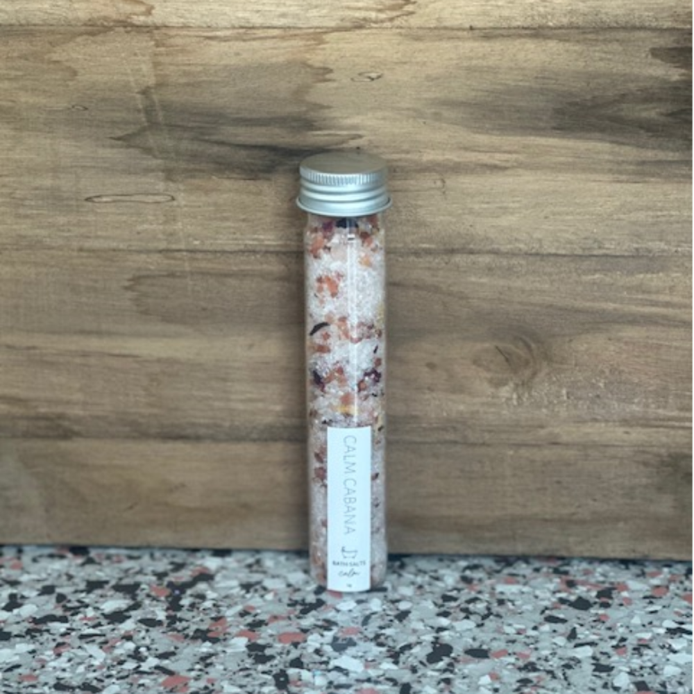 Calm Cabana 'Calm' Bath Salts in a glass tube against a wooden wall